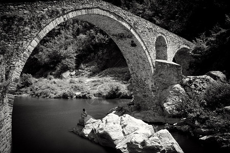 抽象的黑白景观与深林中的旧石桥图片