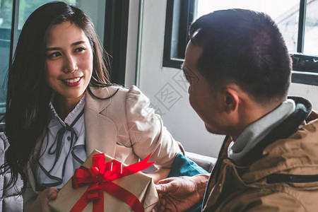 年轻人坐在家里的沙发上正在给可爱的图片