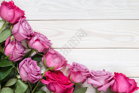 粉红色的玫瑰花布在木制背景图片
