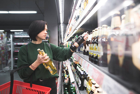 女人在超市里挑选啤酒图片