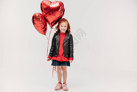快乐的小女孩带着气球以心形状背景图片