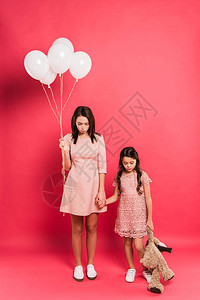 母亲和女儿被白色气球和红色的图片