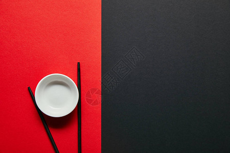 红色和黑色背景的空碗和筷子排图片