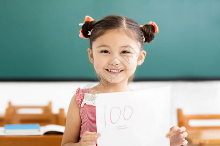 快乐的小女孩在课堂上展示考试论图片