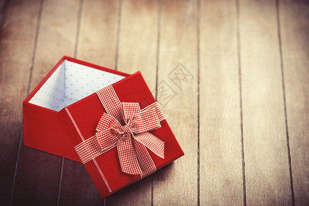 红色礼品盒放在木制桌上照片以彩色反光图片