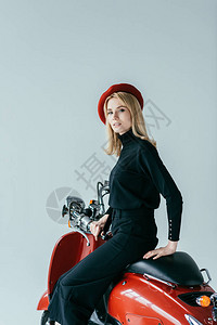 穿着黑色衣服的金发女孩被红色摩托车以灰图片