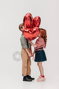 美丽的一对小情侣的侧面站在心形气球图片