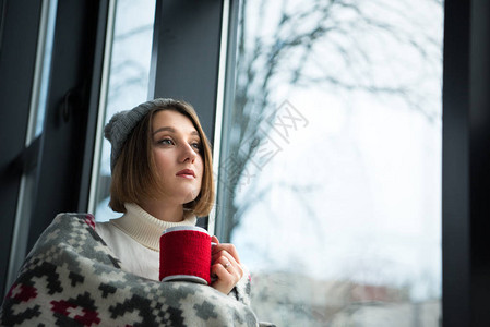 穿着冬衣的女孩拿着红茶图片