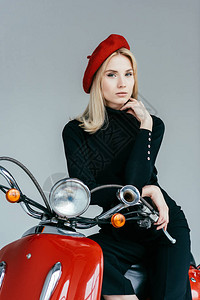 时尚的金发女孩仰赖着古老的骑摩托车图片