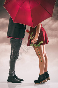 躲在伞后热吻的情侣背景