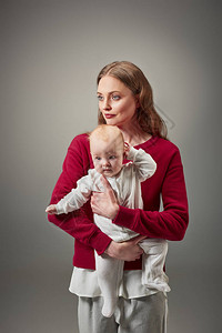 美丽的时尚母亲抱着可爱的幼女在图片