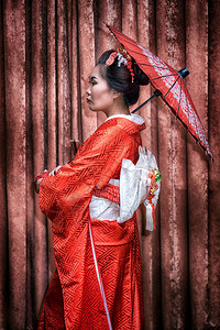 日本和服女子手持红色传统伞的肖像图片