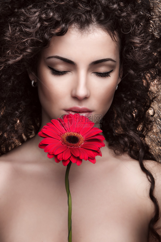 美丽的黑发女人与红花图片