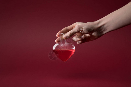 女握着心形玻璃瓶的爱灵丹酒背景图片