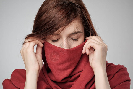 红发女人用围巾遮脸的肖像图片