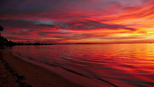 红色的天空映照在塞班岛加拉班的水域背景图片
