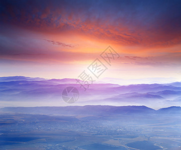 多云山上的日落景观图片