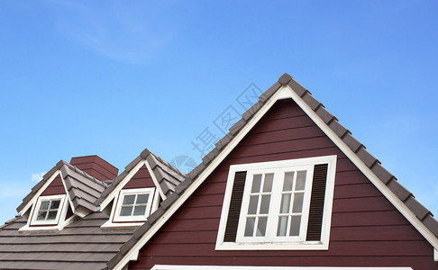 在蓝天的映衬下花园里的棕色瓦屋顶背景图片
