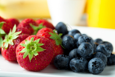 新鲜的草莓和蓝莓背景是橙汁图片