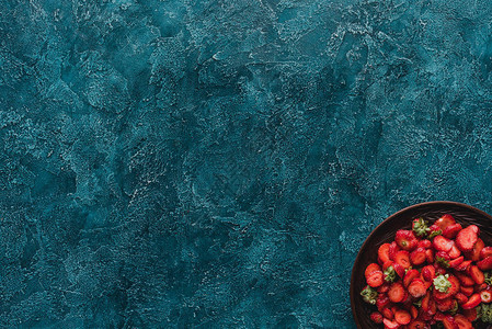 蓝色混凝土表面成熟草莓碗的顶部视图图片
