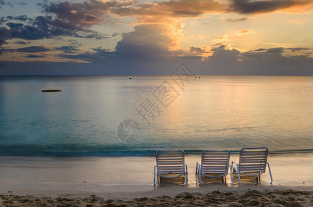 日落时在海滩上三张空椅子在大开曼岛七里边图片