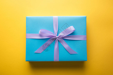 蓝色礼品盒的顶部视图黄背景图片
