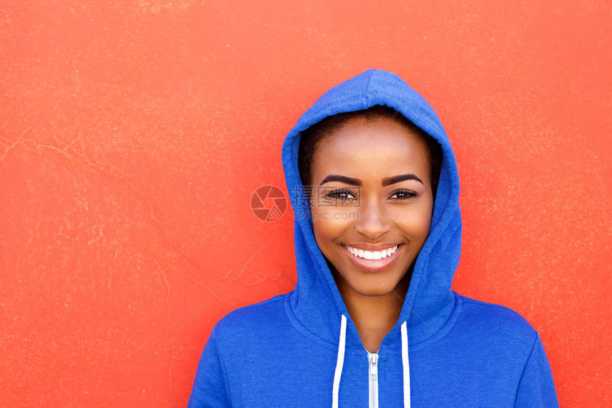 美丽年轻黑人女子在红色背景下微笑的近距离肖图片