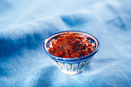 传统自制的玫瑰香露蓝底陶瓷碗中的红辣图片