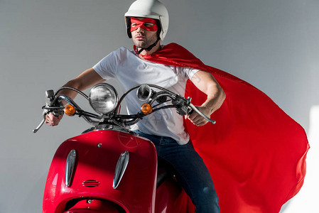 穿着保护头盔和超级英雄服装的人骑图片