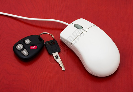 一台电脑鼠标用一套车钥匙在红色背景上背景图片