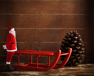 木制红色雪橇棕色松果和圣诞老人图片