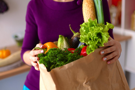 健康健康的幸福妇女拿着一个纸袋买满水果图片