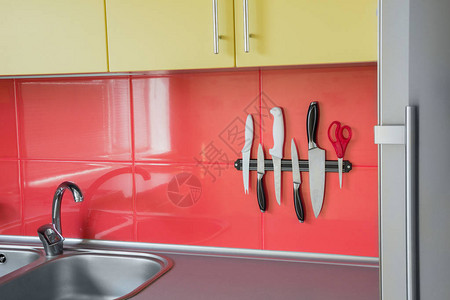 刀片磁铁在厨房的红瓷砖背图片