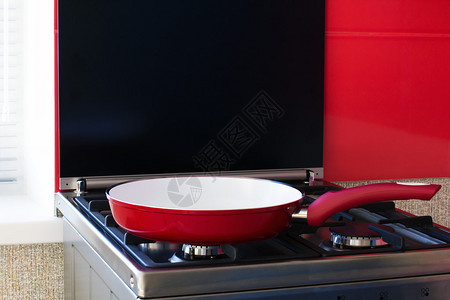 厨房燃气灶上的红色煎锅图片