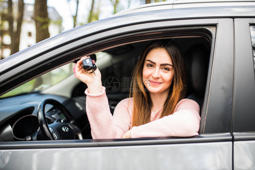 快乐的女司机展示车钥匙图片