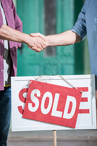 男人与推销员握手并购买新房的剪影图片