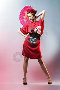 时装女郎穿着传统的日本红和服带着雨伞图片