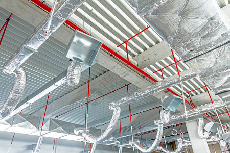 银绝缘材料中的通风管道和红管上的灭火器从天花板上挂在新大楼内b图片