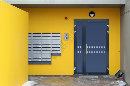 邮箱在新房子一扇门附近的黄色墙上加密锁和图片