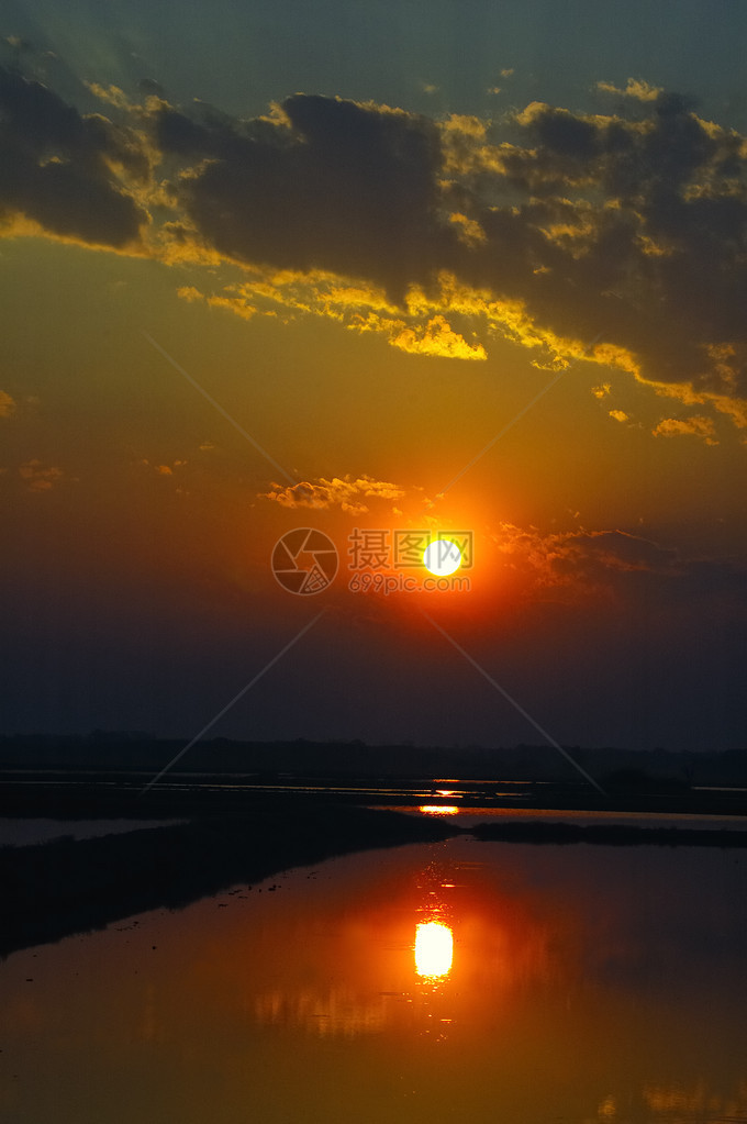 太阳在沼泽中升起阴云的天空垂直方向惊图片