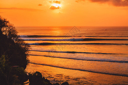 五颜六色的日落或日出与海洋和冲浪的大浪图片