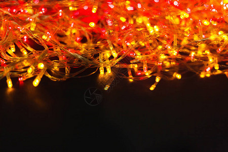 圣诞红灯和黄灯背景复制空间黑色木板表面闪亮的假日园地Xma树装饰冬图片