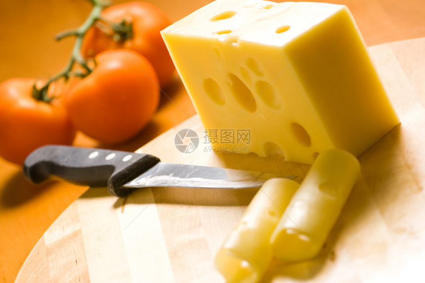 木桌上的美味奶酪背景是番茄图片
