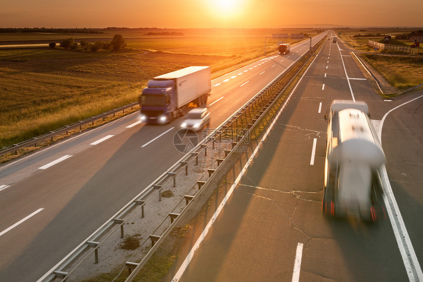 卡车和汽车在驶向夕阳的高速公路上运动模糊在贝尔格莱德塞尔维亚附近的高速公路图片