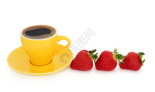 咖啡在黄色的杯子里上面有碟子和草莓水果在图片