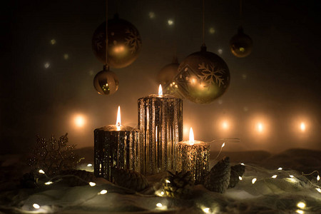 在深色背景上燃烧蜡烛的圣诞装饰在暗金色背景灯的圣诞饰品创图片