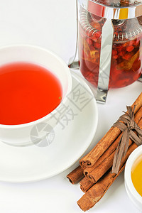 一杯热浆果茶配肉桂棒和蜂蜜图片