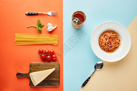 在餐具附近的盘子上铺有美味的意大利面和番茄酱图片