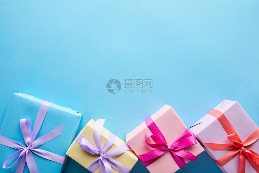 蓝色背景上彩色礼品盒的顶部视图图片