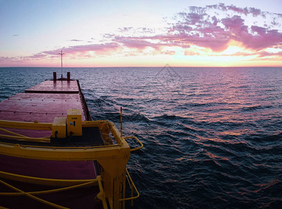 货运驳船的红色甲板和海景上的日落图片